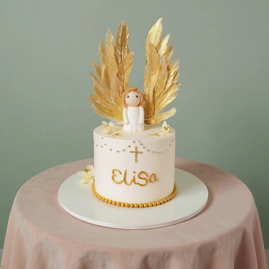 A single-tier ivory baptism cake featuring a fondant angel figurine with large upright golden wafer paper wings, decorated with a gold cross and edible pearls by PuffyClouds in Kochi